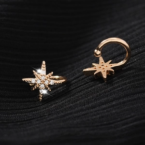 Bagues d'oreille étoile du Nord en or rose avec zircons sur fond de tissu noir