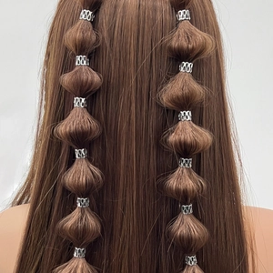 Silver hollow hair rings used on a bubble braid hairstyle for decorative dreadlock styling