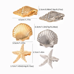 Macro detail of alloy starfish and seashell hair clips in gold and silver plating