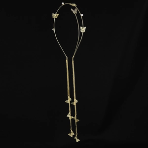 Detail of golden butterfly headband with long chain tassels and white pearl accents