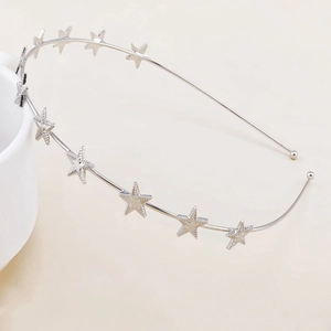 Detail of silver star headband showing textured metal stars and protective round ends