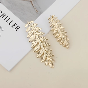 Detail view of golden leaf hair clips set with realistic vein texture and pearl accents