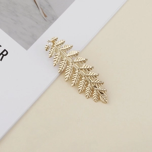 Elegant gold leaf hair clip with realistic vein textures and a single white pearl detail