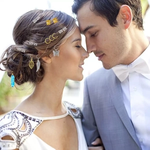 Detail of hair charms and dreadlock rings featuring crystals and leaves in a styled braid