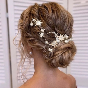 Detailed view of moon and star crystal hair clips set on a professional bridal hairstyle