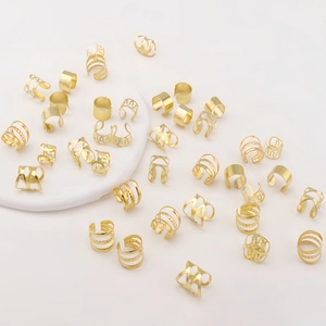 Detailed macro of assorted gold plated adjustable c-shaped hollow rings for hair braids