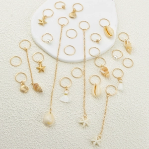 Golden ocean shell hair rings set with starfish, pearls, and tassels on white background
