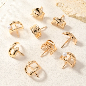 Close-up of minimalist gold-plated alloy stud earrings set with pearl accents and geometric shapes