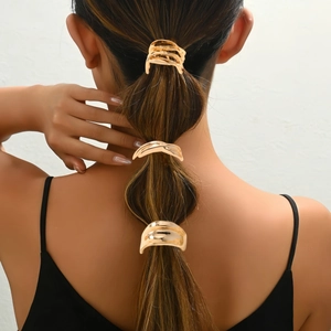 Close-up of three golden minimalist alloy hair clips styled on a woman's ponytail