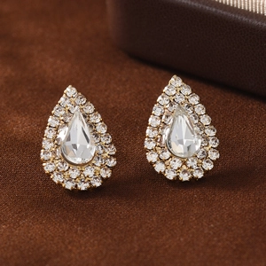 Boucles d'oreilles gouttes dorées élégantes avec halo de cristaux sur fond texturé