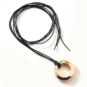 Minimalist gold circle pendant on black cord necklace, sleek unisex jewelry style