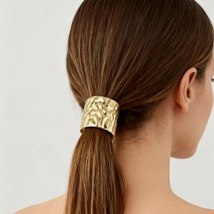 Minimalist golden metal hair hook with hammered texture design on low ponytail