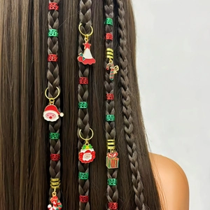 Close-up of Christmas themed dreadlock charms featuring Santa and trees on braided hair