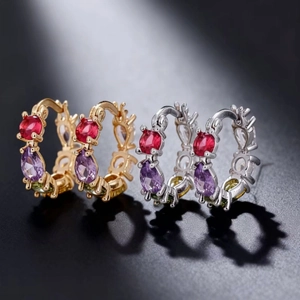 Detail of copper hoop earrings with multicolor cubic zirconia in gold and silver plating