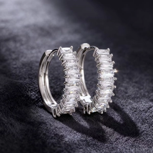 Hoop earrings in silver color with baguette cut zirconias and secure hinge closure