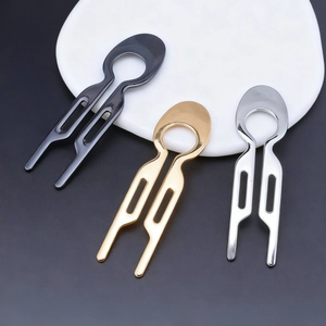 Minimalist U-shaped metal hairpins in black, gold, and silver finishes on a ceramic plate