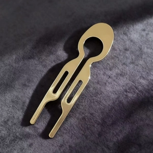 Detail of a minimalist gold U-shaped hair pin on elegant velvet fabric background