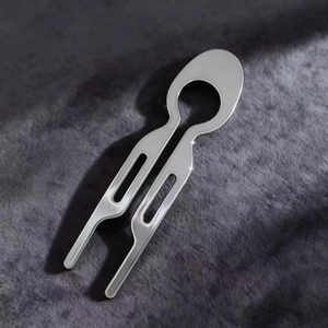 Polished silver U-shaped hair stick with oval hollow design on grey velvet