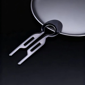 Macro view of minimalist silver U-shaped metal hair pin with black circular top design