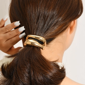 Polished gold metal ponytail cuff with geometric layered design for low ponytail hair styling