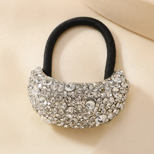 Dettaglio macro di un elastico per capelli di lusso con strass su seta color champagne