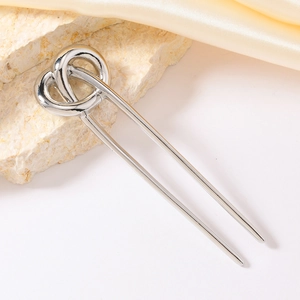Elegant silver U-shaped hair pin with heart knot design on luxury silk fabric