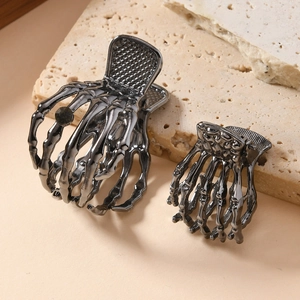Gothic skull hand metal hair claws set in gunmetal finish on stone display base
