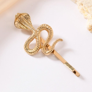 Detailed close-up of golden cobra snake hair clip showing textured scales and alloy finish