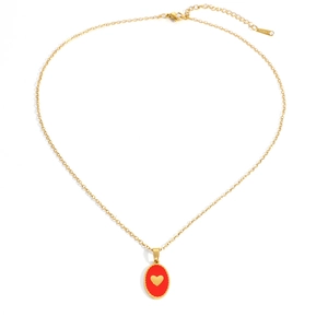 Dettaglio della collana in acciaio dorato con pendente a cuore rosso e chiusura a moschettone