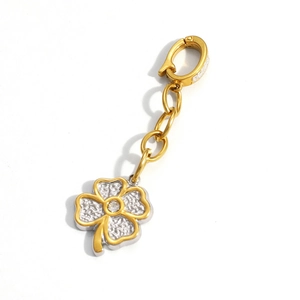 Close-up of a two-tone clover charm with gold edges and silver textured center