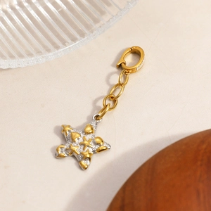 Starfish pendant with 18K gold star pattern on a two-tone metal sea-inspired charm