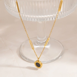 Elegant 18K gold plated stainless steel necklace with round black pendant on glass edge
