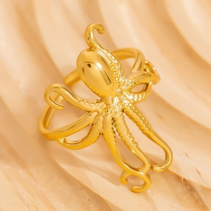 Polished 18K gold octopus open ring with detailed tentacle suckers on beige background