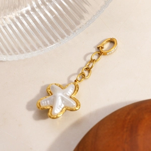 Detail of 18K gold star fish pendant with white mother of pearl inlay and crystal clasp