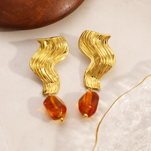 Vue détaillée des boucles d'oreilles ondulées plaquées or 18K avec pierres d'ambre