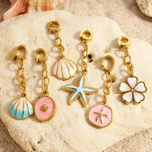 Detailed set of 6 marine enamel charms with shells and starfish on natural beach rocks
