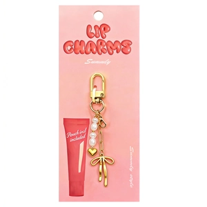 Detail of 18K gold-plated bag charm with white pearls, heart pendant and a golden bow