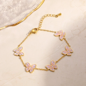Detail eines 18K vergoldeten Schmetterlingsarmbands mit lila-rosa Emaille-Anhängern