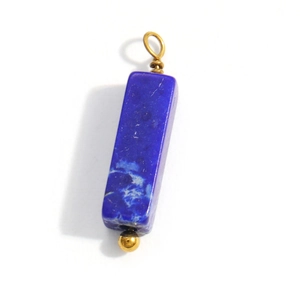 Macro detail of deep blue lapis lazuli cylinder pendant with gold wire wrapping