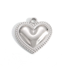 Detailed macro view of polished stainless steel heart pendant with beaded edge finish