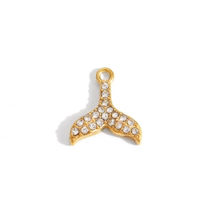 Macro detail of a gold-plated fishtail pendant featuring sparkling cubic zirconia stones
