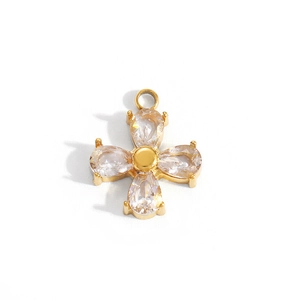 Macro shot of gold-plated cross pendant with teardrop-shaped cubic zirconia and metal ring