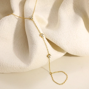 Gold stainless steel clover hand chain with shimmering crystals and integrated finger ring
