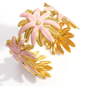 Detail of gold-plated daisy flower bracelet with pink enamel petals and open cuff design