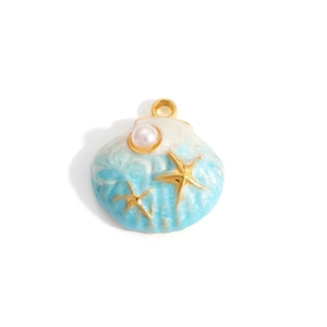 Macro view of shell pendant with gold plating, blue enamel, starfish, and pearl details