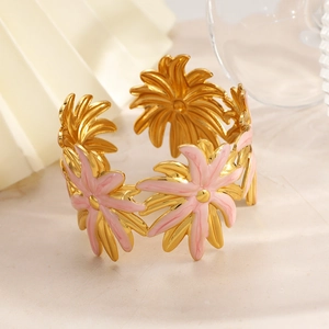 Detailed macro view of gold plated adjustable cuff bracelet with pink enamel flowers