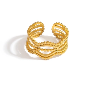 Macro shot of gold plated multi-layer wavy ring featuring intricate beaded texture edges