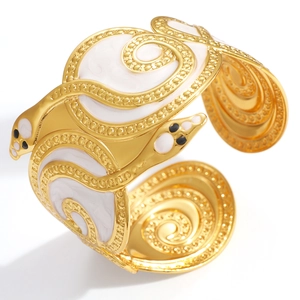 Detailed view of gold snake-shaped bangle featuring white enamel inlay and black stone eyes