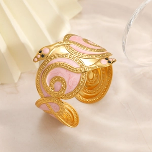 Adjustable gold plated snake wrap bangle featuring pink enamel and beaded textures
