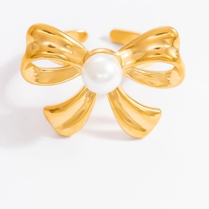 Close-up of gold-plated bow ring featuring a polished central white pearl detail
